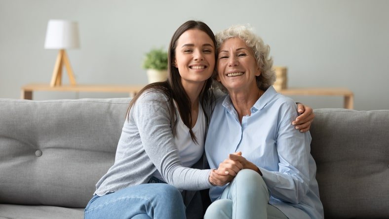 Adult daughter hugging her senior mom in her new independent living apartment.