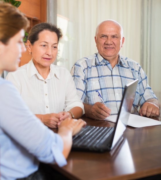 Senior couple sitting down with a senior advisor discussing care options.